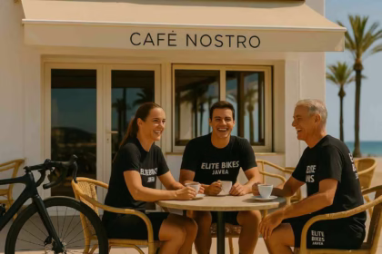 happy cyclists enjoying coffee at Café Nostro in Jávea, wearing Elite Bikes Jávea shirts, with bikes parked nearby under the sunny Costa Blanca sky